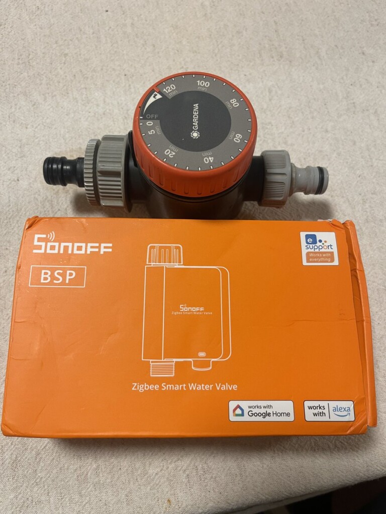 Sonoff SWV Zigbee smart water valve in its box, with the old Gardena mechanical timer it replaced on top