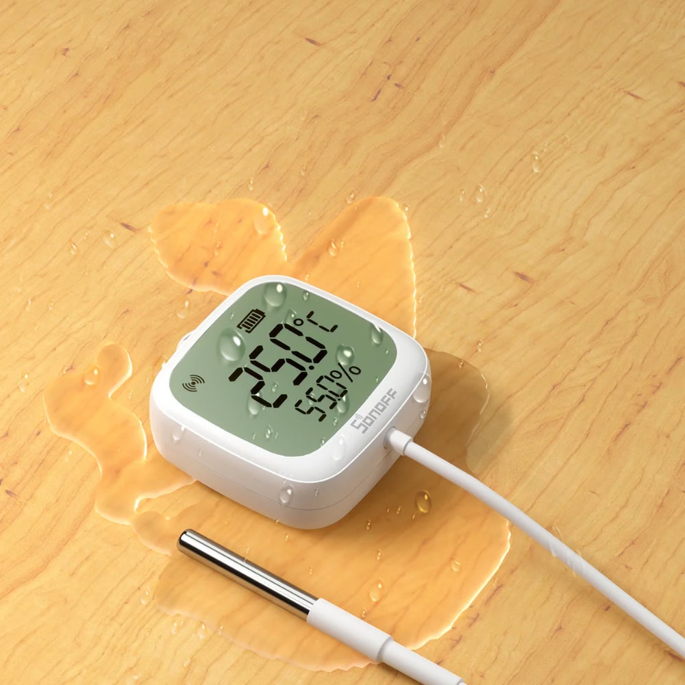 SONOFF SNZB-02LD, the IP65 Zigbee thermometer with an LCD and a stainless wired probe, shown wet on a wooden surface